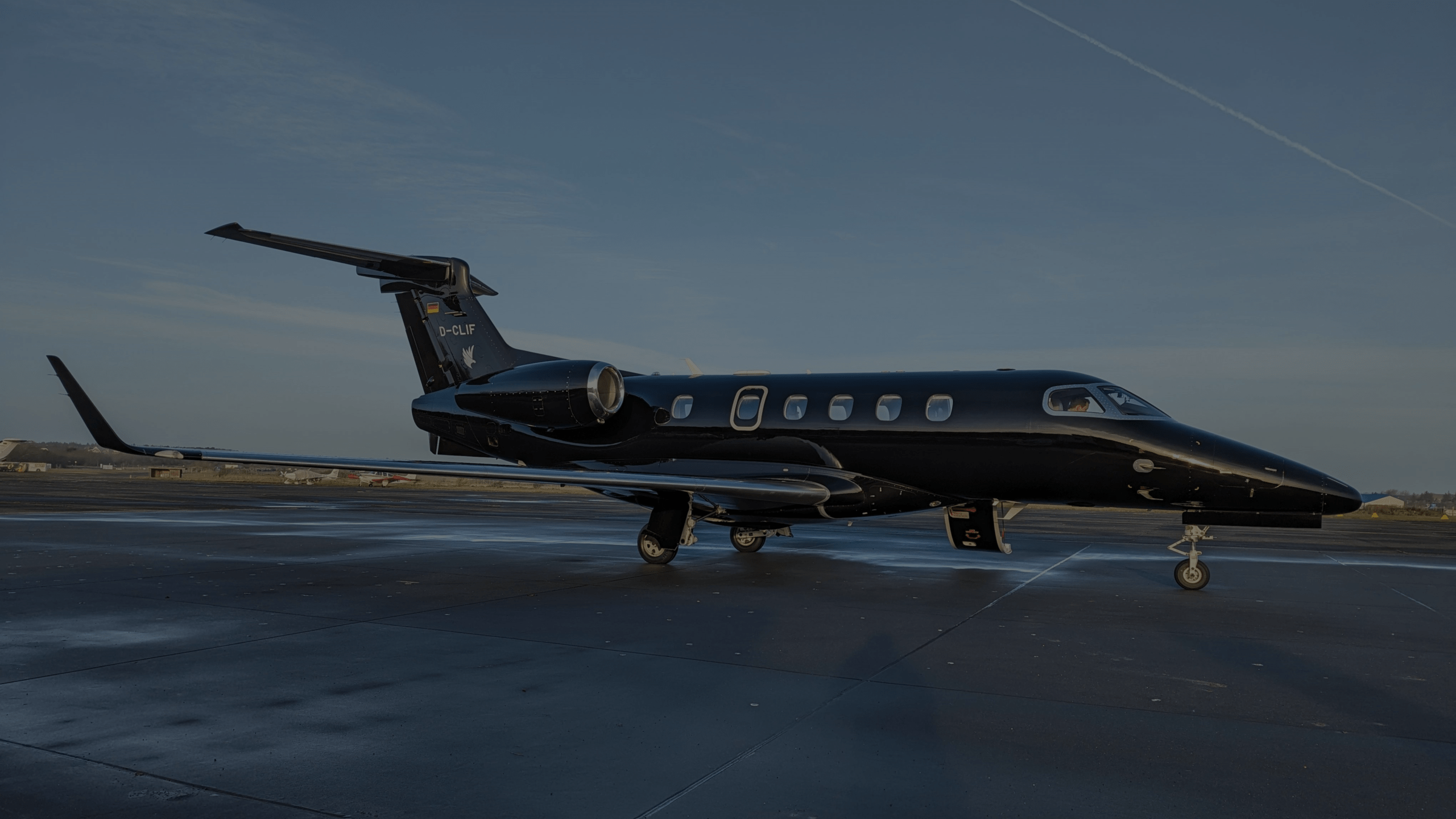 Private jet parked on the tarmac at dusk ready for departure