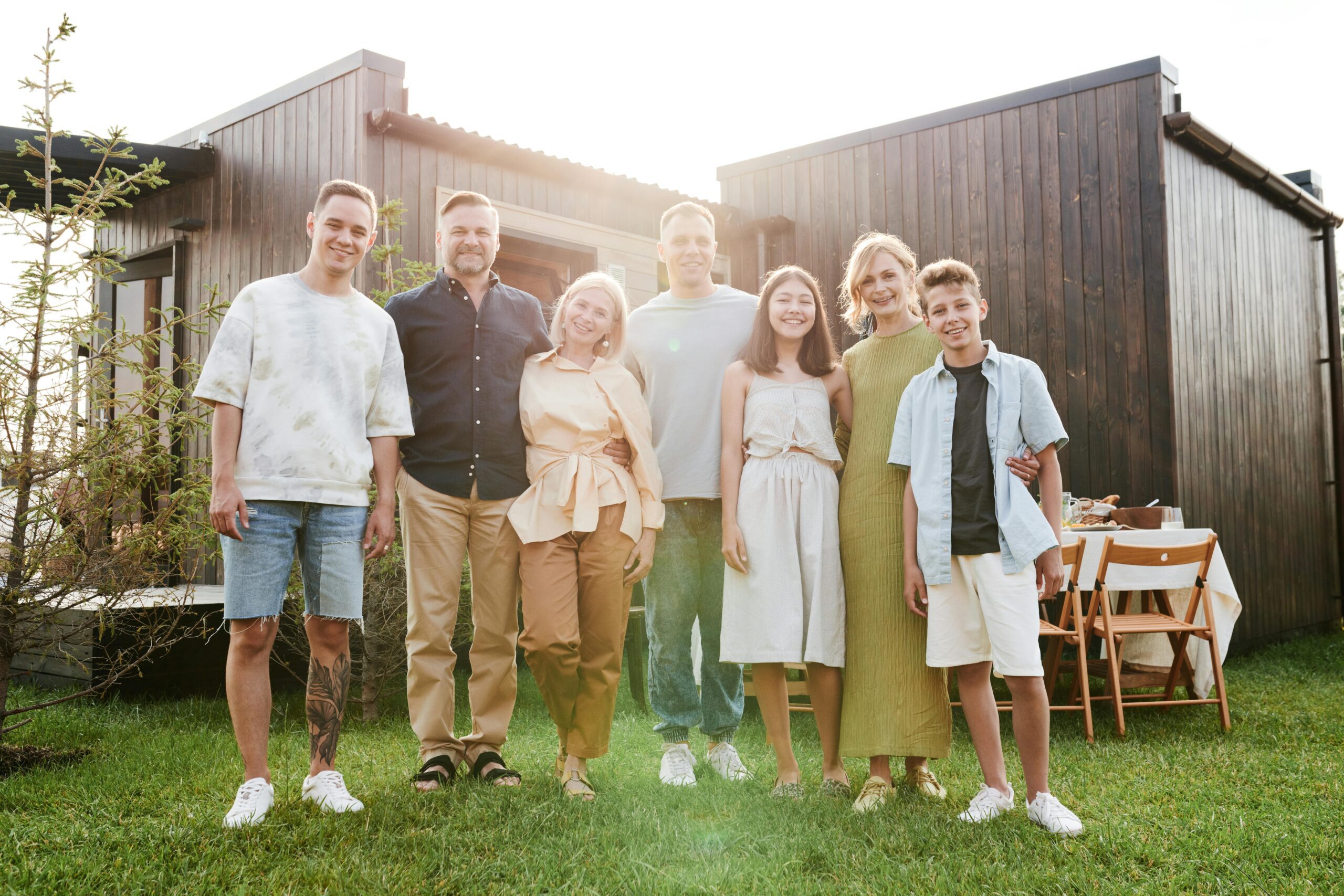 Multigenerational family gathered together outside a modern vacation home