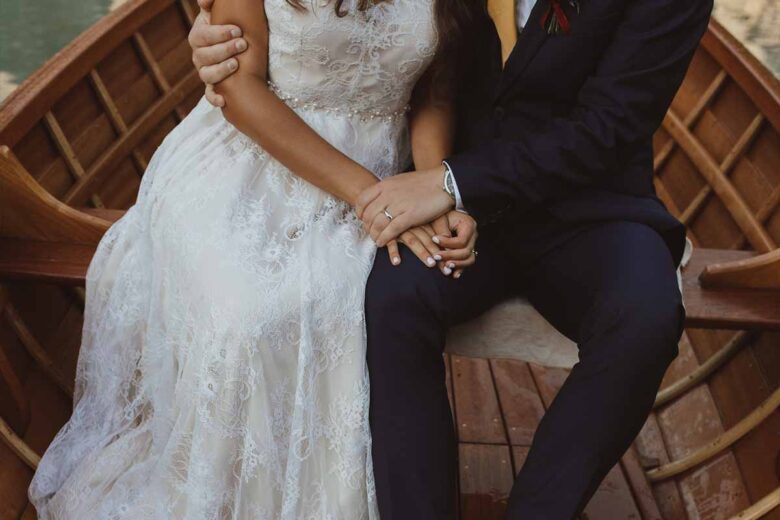 Bride in a lace gown with her groom at a full-scale destination wedding with a guest room block