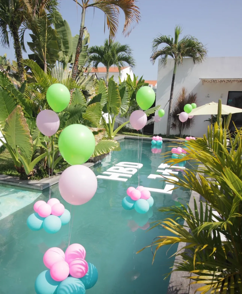 Private villa pool decorated with balloons and floating HBD letters for a birthday celebration